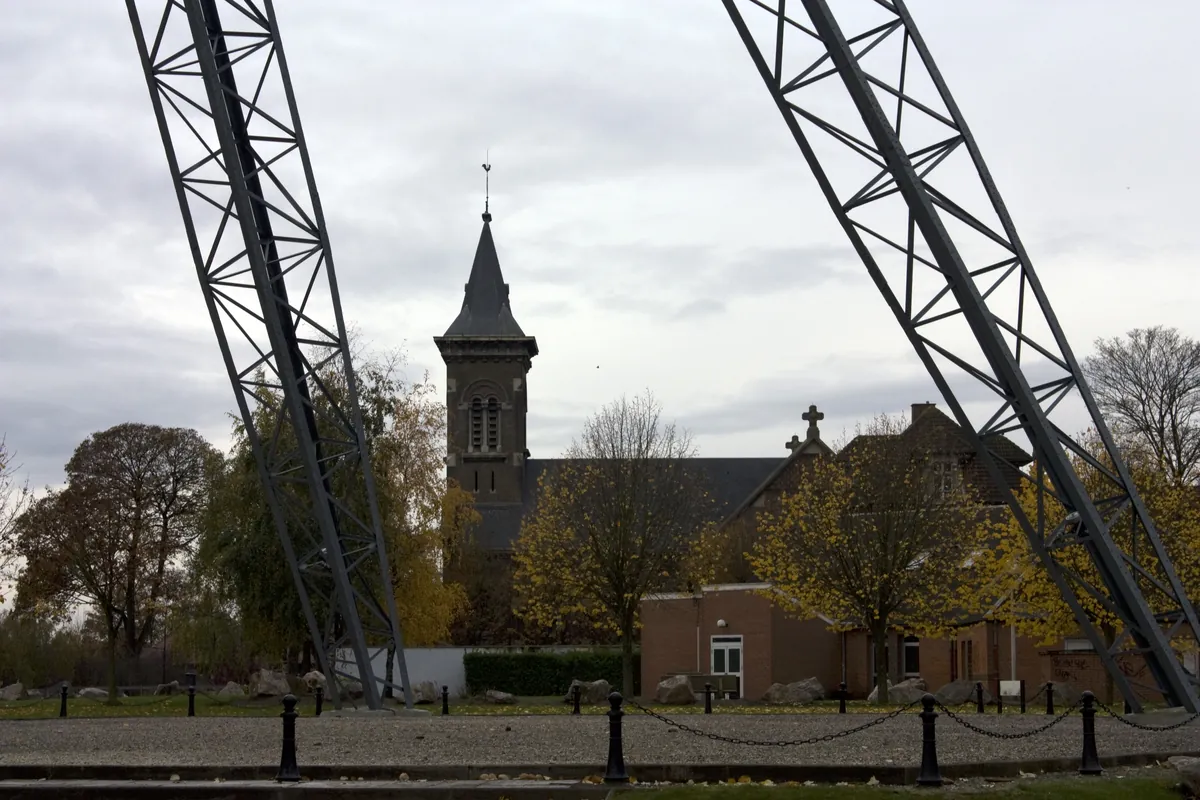 L'église Saint-Amé de Liévin vue entre les montants du chevalement de la fosse 3 bis